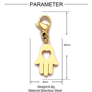 Détail d'un pendentif main de Hamsa en acier doré avec fermoir mousqueton et cœur ajouré