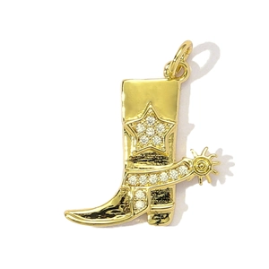 Detailed macro view of 18K gold cowboy boot pendant with cubic zirconia and star design