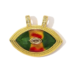 Macro shot of gold-plated evil eye charm with red green enamel and marquise zircon
