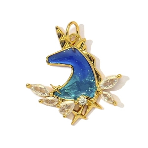 Macro shot of gold unicorn pendant with starry blue enamel and sparkling zircon stones