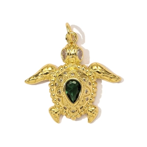 Detailansicht eines goldenen Schildkrötenanhängers mit grünem Edelstein und Zirkonia
