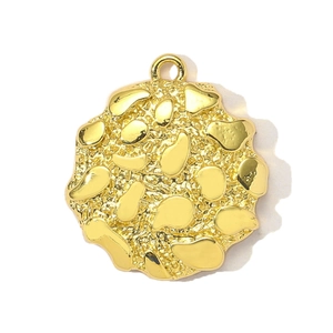 Detail shot of golden circular DIY pendant with artistic hammered texture and polished bumps