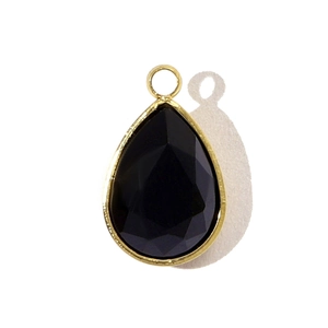 Détail du pendentif goutte en verre noir facetté avec bordure en acier inoxydable doré