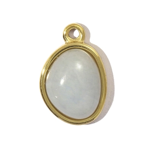Macro detail of teardrop moonstone pendant with a polished gold-plated steel frame