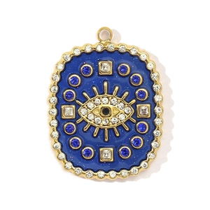 Detailed macro view of gold-plated stainless steel evil eye pendant with blue crystals