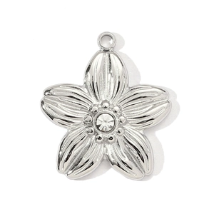 Detailed macro view of a silver flower pendant with textured petals and a center zircon