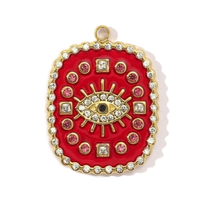 Macro shot of oval red enamel evil eye pendant with sparkling crystals in gold finish