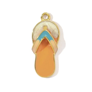 Macro detail of flip-flop pendant with orange enamel and blue straps for DIY jewelry