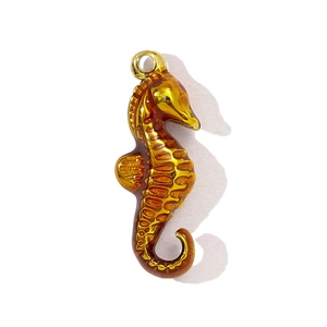 Detailed view of seahorse-shaped stainless steel pendant with gold and amber enamel finish