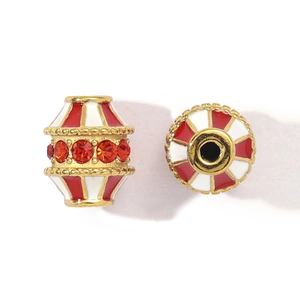 Detailed macro view of red and white enamel beads with orange rhinestones and gold trim
