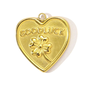 Close-up of heart-shaped gold titanium pendant featuring Good Luck clover engraving