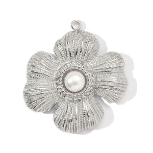 Close-up of silver sunflower pendant with central pearl bead and textured petals