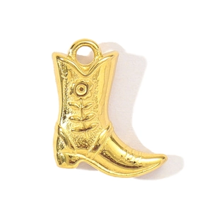 Dettaglio di un ciondolo a stivale da cowboy dorato con trama floreale per gioielli DIY