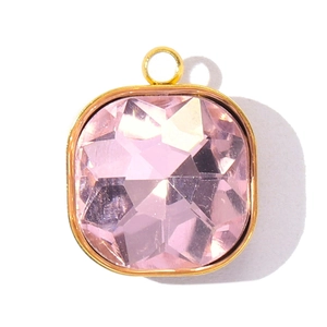 Détail d'un pendentif en cristal rose carré avec monture dorée et anneau fixe