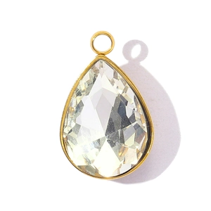 Macro detail of faceted teardrop crystal pendant with gold-plated stainless steel frame