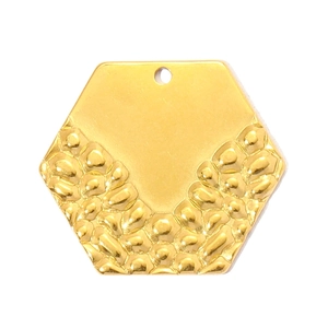 Detail of hexagonal gold pendant with smooth mirror finish and hammered texture