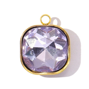 Détail macro d'un pendentif carré en verre de cristal violet avec taille à facettes et bord or