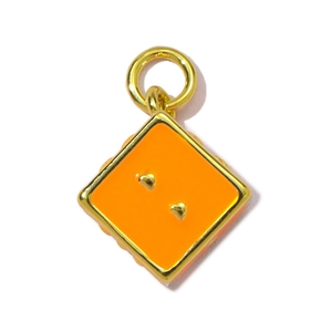 Macro detail of square orange enamel dice pendant with golden dots and brass jump ring