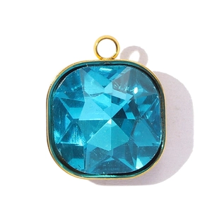 Gros plan d'un pendentif en cristal bleu ciel taille coussin avec monture en acier doré