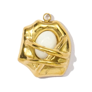 Detailed macro view of an artistic gold-plated stainless steel teardrop pendant with white stone