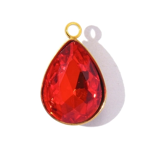 Detailed view of a faceted red pear-shaped crystal pendant with a golden metal ring