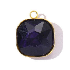 Détail macro d'un pendentif en cristal violet foncé avec bords en acier inoxydable doré