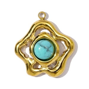 Detail van vintage bloem hanger met turquoise steen in een gouden onregelmatige lijst