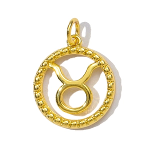 Macro detail of a vintage Taurus zodiac pendant in gold-plated brass with beaded edges