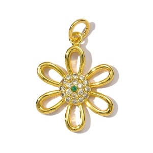 Detailed view of a gold flower pendant with zircons and a green center stone