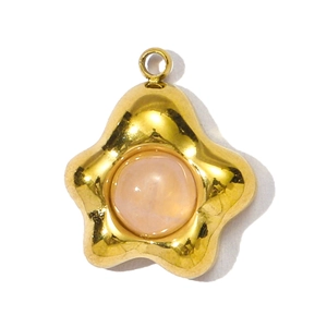 Gedetailleerd beeld van een gouden stervormige hanger met een roze edelsteen