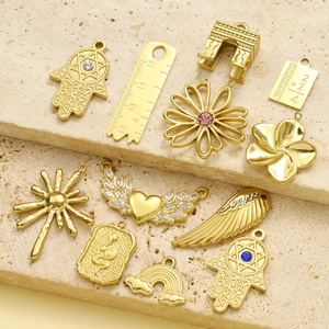Pendentifs en acier titane doré avec main de Fatima, ailes de cœur et arc sur pierre