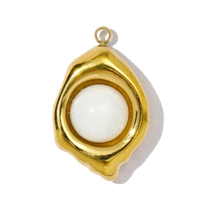 Detail van een gouden, onregelmatige hanger met een witte bolvormige edelsteen inleg