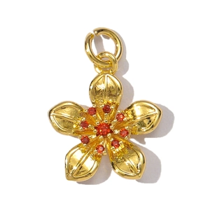 Detailed view of a gold flower pendant with red zircon and textured petals for jewelry making