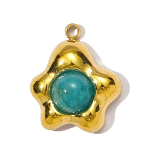 Detail van een goudkleurige stervormige hanger met een ronde blauwe steen in het midden