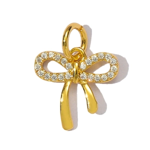 Close-up of golden bow-shaped pendant with pavé white cubic zirconia stones