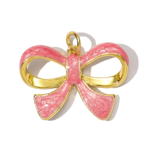 Detailed close-up of a pink enamel bow-shaped pendant with gold plating and sparkling glitter