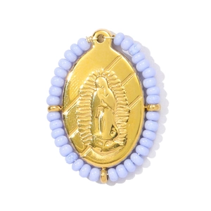 Détail d'un pendentif ovale Vierge Marie doré avec perles lavande et finition polie