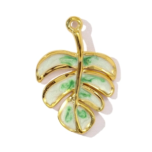 Macro shot of tropical leaf pendant with gold borders and marble-effect green enamel