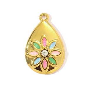 Close-up of golden teardrop pendant with colorful enamel flower and sparkling zircon