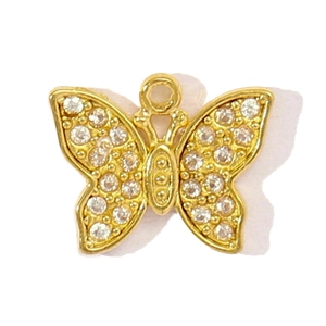 Détail d'un pendentif papillon doré serti de zircons pour la création de bijoux DIY