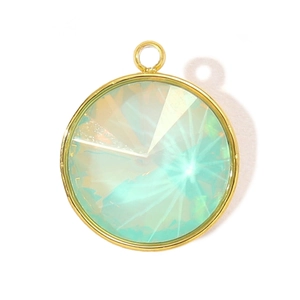 Macro shot of circular gold stainless steel pendant with iridescent crystal gemstone