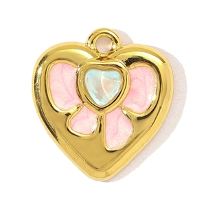 Close-up of heart-shaped gold pendant with pink glitter and opal-like gem detail