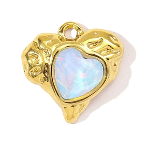 Macro shot of gold heart pendant featuring a melt-texture metal surface and opal-style stone