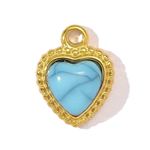 Vue détaillée du pendentif cœur doré avec pierre turquoise et bords perles