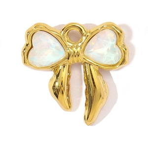 Close-up of golden bow pendant featuring iridescent heart-shaped opal stone details