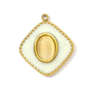 Macro detail of a vintage gold drop pendant with cat-eye stone and beaded texture