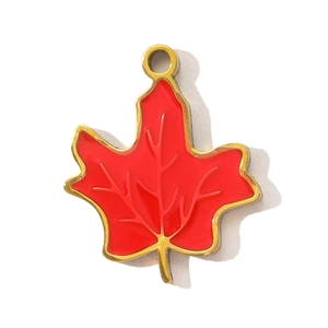 Detailed macro view of a red enamel maple leaf pendant with a polished gold metal edge