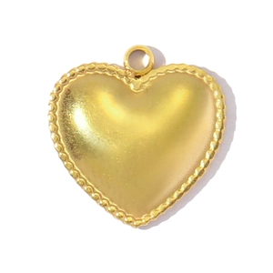 Detail of a golden heart pendant featuring textured bead edges and a round bail connector