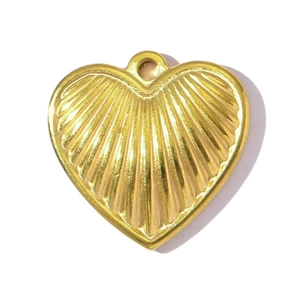 Macro shot of gold-plated ribbed heart pendant with radiated texture for jewelry making