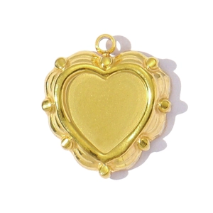 Detailed macro view of a golden heart-shaped pendant with wavy edges and beaded texture